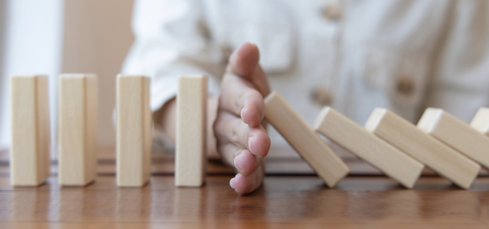 LimitsWeb Story Post hand stopping falling dominoes to keep other dominoes steady