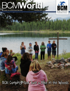 people standing by a cross by a pond