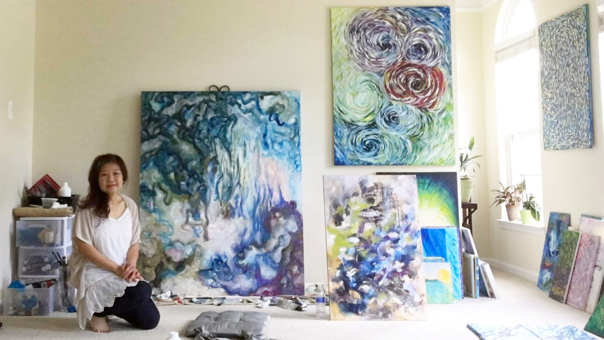 Flo Tan with abstract oil paintings