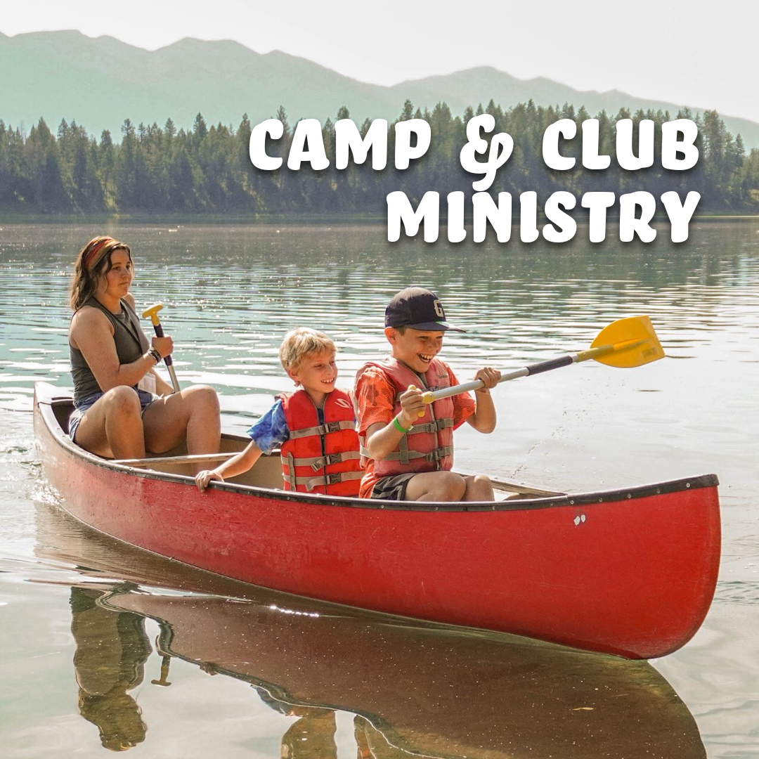 two campers and a counselor canoeing on a lake