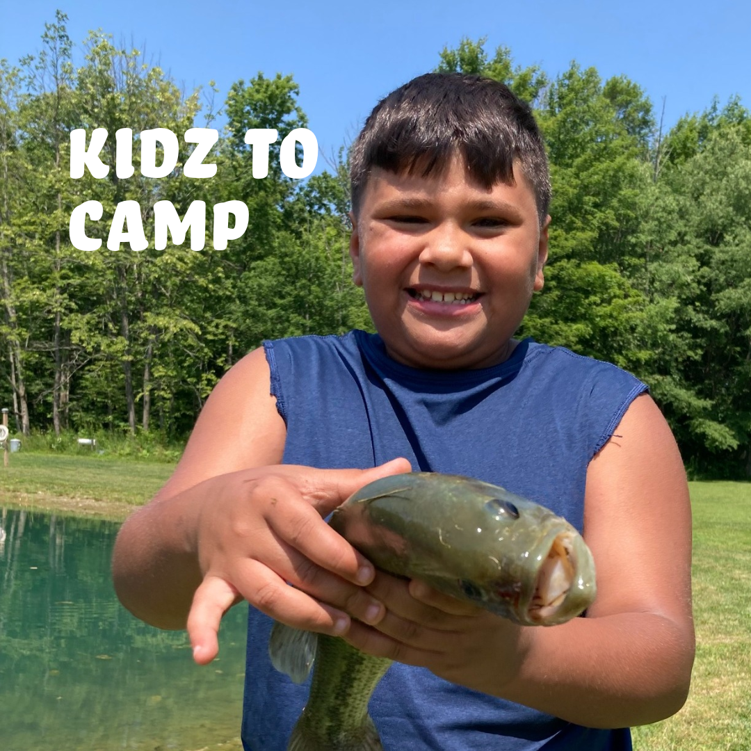 young camper holding a fish he caught